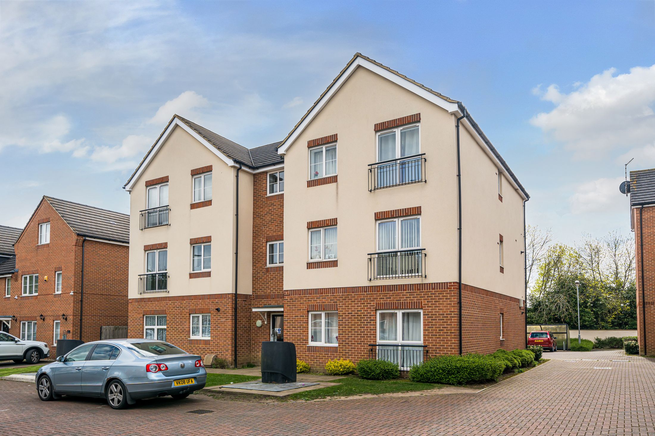 A six-apartment block in red brick and cream render